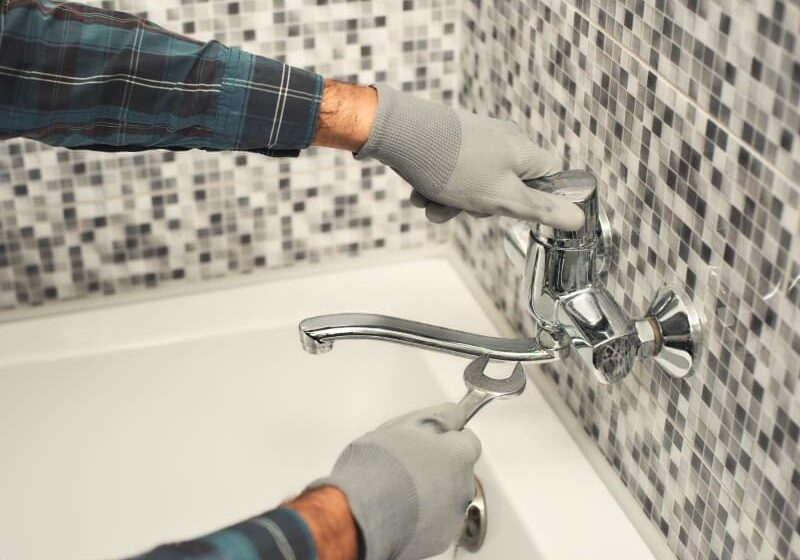Plumber repairing bathroom faucet.